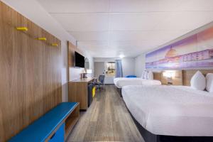 a hotel room with two beds and a tv at Days Inn by Wyndham Fredericksburg North in Fredericksburg