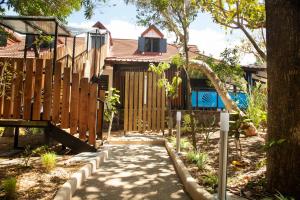un jardin avec une clôture en bois et un trottoir dans l'établissement Villa des 3 sables, MACABI, à Étang-Salé les Bains