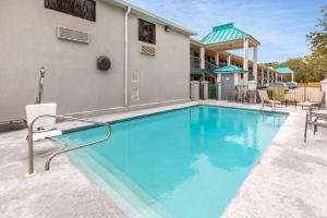 einem großen blauen Pool vor einem Gebäude in der Unterkunft Baymont by Wyndham Biloxi - Ocean Springs in Biloxi