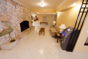 a living room with a stone fireplace and a couch at Ramada by Wyndham Houston Intercontinental Airport East in Humble