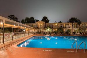 a large pool in front of a hotel at night at Ramada by Wyndham Houston Intercontinental Airport East in Humble
