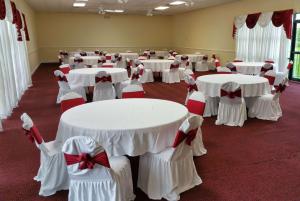 a room with white tables and chairs with bows at Ramada by Wyndham Houston Intercontinental Airport East in Humble