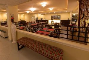 a restaurant with a bench in front of a counter at Ramada by Wyndham Houston Intercontinental Airport East in Humble