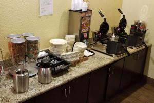 a counter with plates and dishes on a counter top at Ramada by Wyndham Houston Intercontinental Airport East in Humble