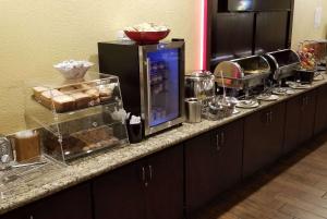 a kitchen counter with a buffet of food on it at Ramada by Wyndham Houston Intercontinental Airport East in Humble