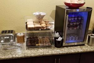 a counter with a refrigerator filled with lots of donuts at Ramada by Wyndham Houston Intercontinental Airport East in Humble