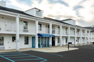 an empty parking lot in front of a white building at Baymont by Wyndham Prattville - Montgomery in Prattville