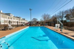 uma piscina com água azul em frente a um edifício em Baymont by Wyndham Prattville - Montgomery em Prattville