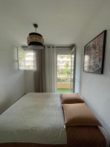ein großes Bett in einem Zimmer mit Fenster in der Unterkunft Petit cocon à Sanary-sur-Mer in Sanary-sur-Mer