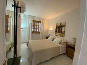 a white bedroom with a bed and a window at Bungalow Einstein in Maspalomas +28 photos