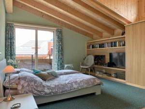 a bedroom with a bed and a large window at Mountain 4U in Meiringen