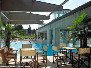 een patio met tafels en stoelen en een zwembad bij Appartement Aix-les-Bains, 2 pièces, 2 personnes - FR-1-555-48 in Aix-les-Bains