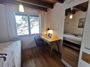 a bedroom with a desk and a bed and a window at Ferienhaus Seppi "Seen und Berge" in Seelisberg