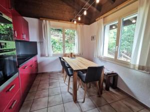 uma cozinha com uma mesa de madeira e cadeiras em Ferienhaus Seppi "Seen und Berge" em Seelisberg