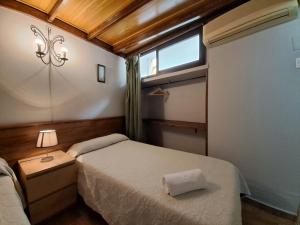 niewielka sypialnia z łóżkiem i oknem w obiekcie Pensión Riosol w Sewilli
