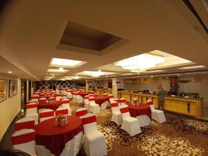 un salón de banquetes con mesas y sillas rojas y blancas en Effotel By Sayaji Dehradun, en Dehradun