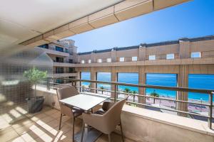 d'un balcon avec une table et des chaises et une vue sur l'océan. dans l'établissement Hyatt Regency Nice Palais de la Méditerranée, à Nice
