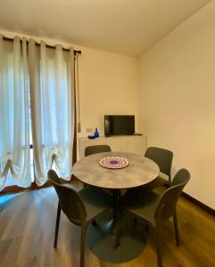comedor con mesa, sillas y TV en Residenza Bella, en Vicenza