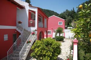 un grupo de casas rojas y blancas con escaleras en Skevoulis Studios, en Benitses