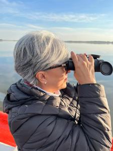 una mujer mirando a través de un par de prismáticos en el agua en La Balsa en José Ignacio