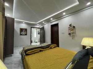 a bedroom with a bed with a yellow comforter at The Realtors Inn Deluxe Cottage Murree in Murree