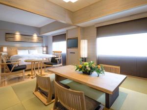 ein Hotelzimmer mit einem Bett, einem Tisch und Stühlen in der Unterkunft Swissotel Nankai Osaka in Osaka