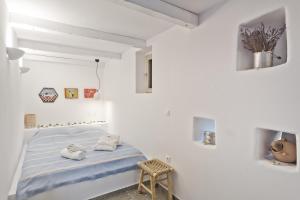 a white room with a bed with towels on it at Blé - Traditional Renovated Cottage in Afiartis