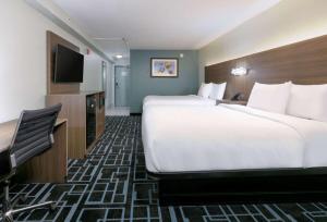 イースト・リッジにあるBaymont by Wyndham Chattanooga Eastridgeのベッド2台、薄型テレビが備わるホテルルームです。