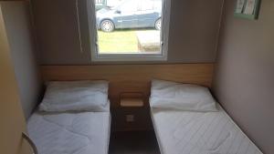 two beds in a small room with a window at 22 Kestrel quays in Flamborough