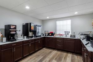 eine große Küche mit braunen Schränken und einem Fenster in der Unterkunft Comfort Inn & Suites in Lexington