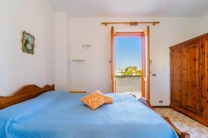 a bedroom with a blue bed and a window at Villino Sabrina con piscina by casavacanzanelsalento in Torre Lapillo +21 photos
