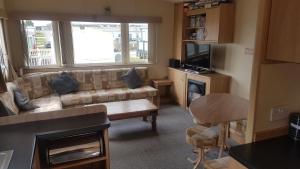 a living room with a couch and a television at 22 Kestrel quays in Flamborough