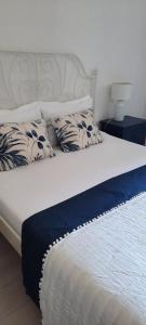 Una cama con almohadas azules y blancas. en Beach house Nada en Korčula