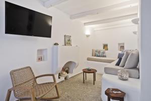 a living room with a couch and a tv at Blé - Traditional Renovated Cottage in Afiartis