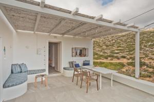 a room with a table and chairs and a view at Blé - Traditional Renovated Cottage in Afiartis