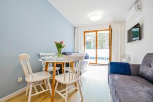 salon ze stołem, krzesłami i kanapą w obiekcie Słońce & Plaża Apartamenty Krynica Morska w Nautikka Park w mieście Krynica Morska