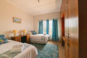 a hotel room with two beds and a window at Bella@Jbay in Jeffreys Bay