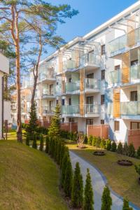 um edifício de apartamentos com um jardim em frente em Słońce & Plaża Apartamenty Krynica Morska w Nautikka Park em Krynica Morska