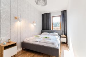1 dormitorio con cama y ventana en Słońce & Plaża Apartamenty Krynica Morska w Nautikka Park, en Krynica Morska