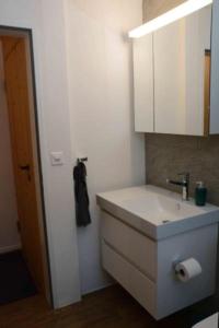 bagno bianco con lavandino e specchio di Chesa Brünella, Wohnung Belvair a Zuoz