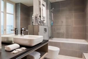 y baño con lavabo, bañera y aseo. en Timhotel Montmartre, en París