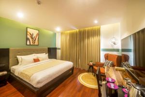 a hotel room with a bed and a television at Olive MG Road Dunsvirk Inn - by Embassy Group in Bangalore