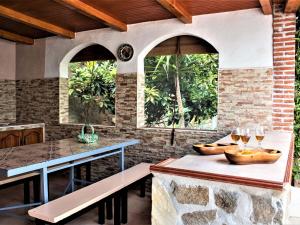 an outdoor kitchen with a table and two windows at Casa La Ronda. in Jódar