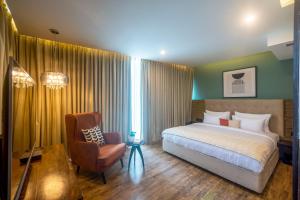 a bedroom with a bed and a chair at Olive MG Road Dunsvirk Inn - by Embassy Group in Bangalore
