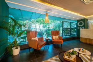 バンガロールにあるOlive MG Road Dunsvirk Inn - by Embassy Groupのリビングルーム(椅子2脚、テーブル付)