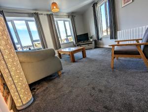 a living room with a couch and a tv at Stylish penthouse apartment in Ramsgate