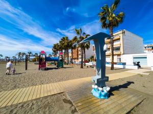 un parque infantil en una playa con palmeras en Apartamento Sunset Algarrobo by Solset, en Algarrobo Costa