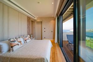 um quarto com uma cama grande e uma janela grande em Mare Deluxe Residences & Villas em Gündogan