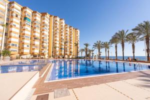 un gran hotel con piscina y palmeras en Apartamento Sunset Algarrobo by Solset, en Algarrobo Costa