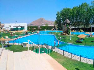 una gran piscina con agua azul en un parque en Casa La Ronda., en Jódar